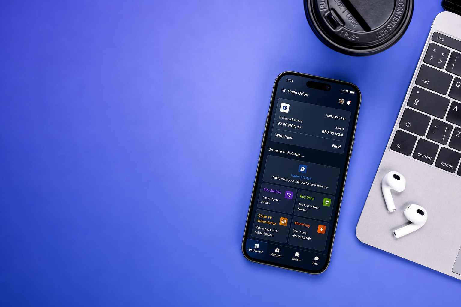 Kaapo dashboard on phone beside laptop and gift card